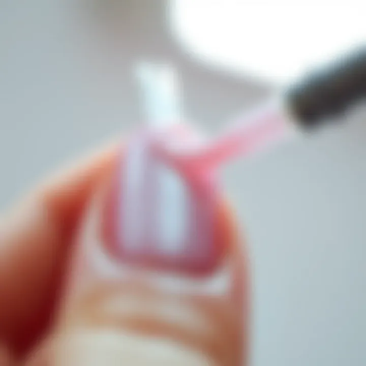 Close-up of pink glue application on nail art