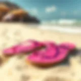 Vibrant Fuchsia Flat Sandals on Beach A pair of vibrant fuchsia flat sandals on a sandy beach